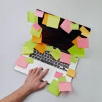 Laptop otoczony notatkami i zadaniami katalogowymi